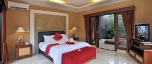 塞米亚克巴厘岛芳香别墅酒店的一间卧室配有一张大床和电视