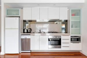 弗里曼特公园巷公寓的厨房配有白色橱柜和冰箱。