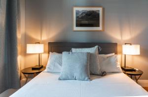 霍巴特塔斯马尼亚宾馆的卧室配有带两盏灯的白色床