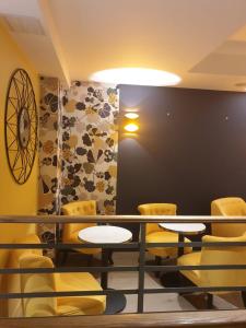 巴黎Panam Hotel PARIS GAMBETTA- Place Gambetta-Mairie du 20 emme的一间设有黄色桌椅的房间和一面墙壁
