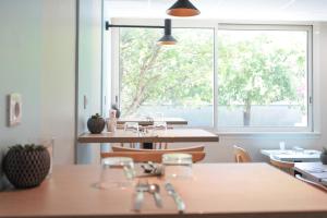 拉罗谢尔Appart'City Classic La Rochelle Centre的一间带桌子和大窗户的用餐室