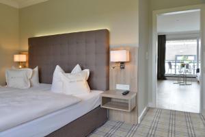 巴特罗森菲尔德德瑞比瑞库恩酒店的一间卧室配有一张大床、床头板和一张桌子