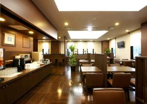 半田半田龟崎茹特酒店的餐厅铺有木地板,配有桌椅