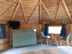 博马勒La cabane de l'Atelier的配有床和两把椅子及一台电视的房间