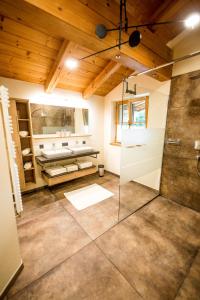 菲伯布伦Leni´s Appartements的一间带玻璃淋浴和水槽的浴室