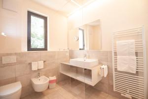 梅拉诺简诗美酒店的一间带水槽、卫生间和镜子的浴室