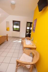 Burg (an der Mosel)Weingut Christian Bucher的配有桌椅和黄色墙壁的客房
