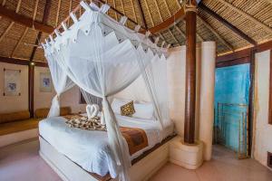 蓝梦岛恍惚湾别墅度假村的一间卧室配有一张带天蓬的床