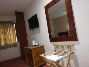 巴西古当福拉瑞酒店的一间设有镜子、椅子和电视的房间