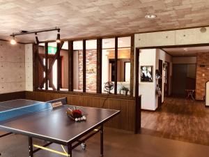 竹田赤川温泉スパージュ-Spaju的客厅配有乒乓球桌和桌子