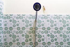 ParitGuest House Taman Sari Syariah的浴室铺有绿色和白色瓷砖,配有淋浴头。