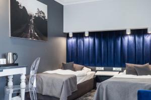 绿山城City Boutique Hotel的配有蓝色窗帘的客房内的两张床