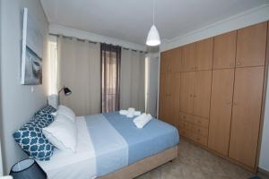 卡拉马塔A beautifull 2nd floor apartment close to the Port的卧室配有蓝色和白色的床以及木制橱柜。