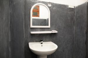 韦利格默Mountain Relax Inn的浴室设有白色水槽和镜子