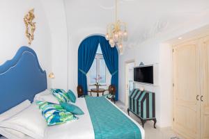 波西塔诺Hotel Eden Roc的蓝色和白色的卧室设有1张床和1台电视