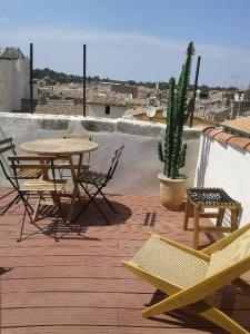 尼姆Appartement avec terrasse panoramique au coeur de Nîmes的天井配有桌椅和仙人掌