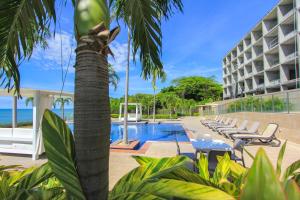 圣卡洛斯PH El Palmar Residences 2203的棕榈树和游泳池的度假村