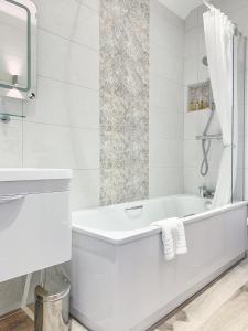 戈斯兰玛丽安斯波特酒店的白色的浴室设有浴缸和水槽。