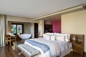 拉安戈斯图拉镇Calfuco Wine Hotel & Spa的一间卧室设有一张大床和一个浴缸