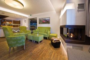 佩特诺伊阿尔贝格Pension Angelika的客厅设有绿色椅子和壁炉