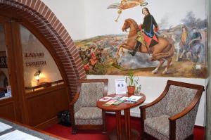 卡罗维发利佩特酒店的墙上有绘画的房间,配有桌椅
