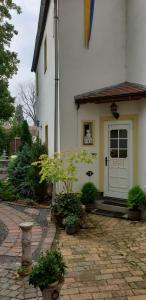 德利茨希Gartenblick Delitzsch的白色的房子,有白色的门和一些植物