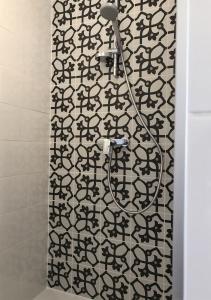 佩里那Finca Zayas Casa Rural & Guest Suites的配有黑色和白色图案的淋浴帘的淋浴