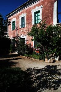 San GregorioLa Madeleine- The House Beyond Time的一座红砖建筑,设有绿色窗户