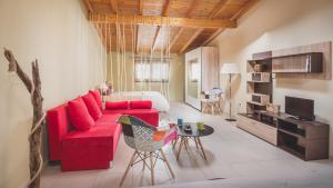 MantoúkionElina's easygoing Apartment的客厅配有红色的沙发和床。