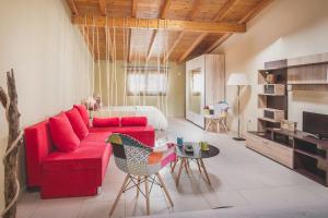 MantoúkionElina's easygoing Apartment的客厅配有红色的沙发和床。