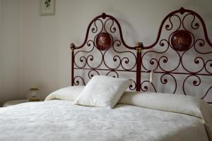 维罗纳阿格利艾塞里住宿加早餐酒店的白色的床,带有红色床头板和白色枕头