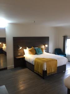 丁格尔Base Dingle的酒店客房配有一张带黄色和蓝色枕头的大床