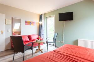 马尔肖Strandhaus Malchow的一间卧室配有红色的床和红色的沙发