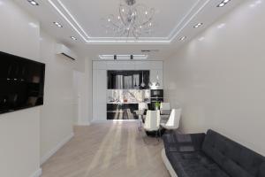 基辅Black&White Apartment in Smart Plaza的带沙发和吊灯的客厅