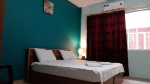 安曼约旦河酒店的一间卧室设有一张带绿色墙壁和窗户的床。