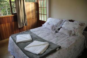 Núcleo MauáChalés Luz da Montanha的卧室里的一张带托盘的床