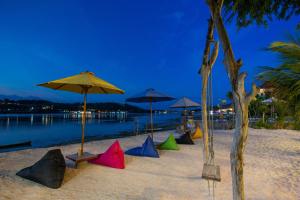 蓝梦岛Wooden Beach Sunset Cottages的海滩上的一组遮阳伞和水