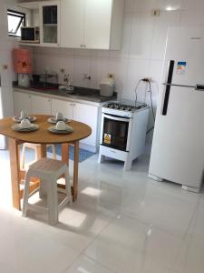 马塞约Beira Mar da Pajuçara的厨房配有桌子和冰箱