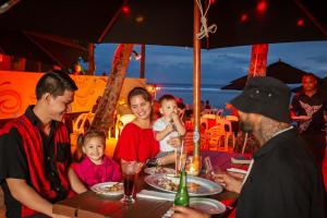 拉罗汤加流浪者度假酒店的一群坐在餐桌上吃食物的人
