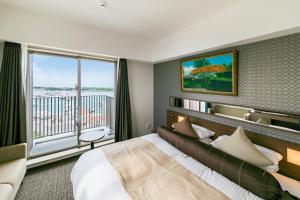 石垣岛宫平酒店的一间酒店客房,设有一张大床和一个大窗户