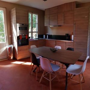 Arnières-sur-ItonManoir du Chambellan的厨房配有木桌和椅子