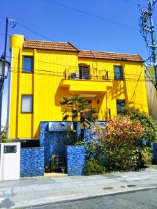 长野独角兽酒店的前面有一棵树的黄色房子