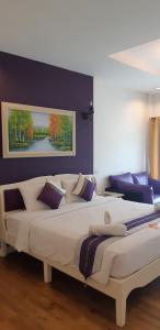 清迈清迈茉莉花精品酒店的卧室配有一张白色大床和紫色墙壁
