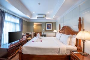 曼谷153号兰花屋度假酒店的一间卧室配有一张大床和一台平面电视