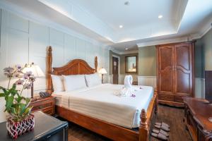 曼谷153号兰花屋度假酒店的一间卧室配有一张大床和木制床头板