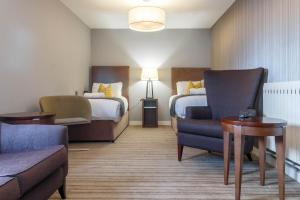 普雷斯顿Samlesbury Hotel的酒店客房,设有两张床、椅子和沙发