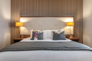 普雷斯顿Samlesbury Hotel的一间卧室配有一张大床和两盏灯