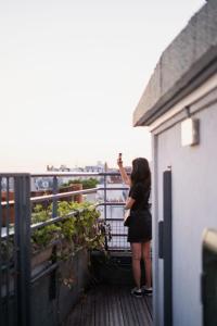 巴黎The People Paris Belleville的一位从阳台上拍下风景照片的女人