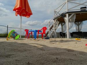 Krajno Pierwszeu Skiby的沙滩上带椅子和遮阳伞的游乐场