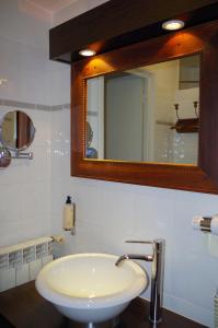桑特Cit'Hotel des Messageries的浴室设有白色水槽和镜子